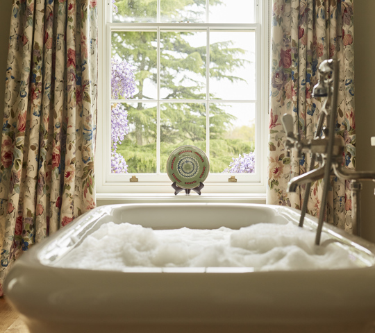 A bath full of bubbles in front of a window