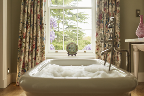 A bath full of bubbles in front of a window