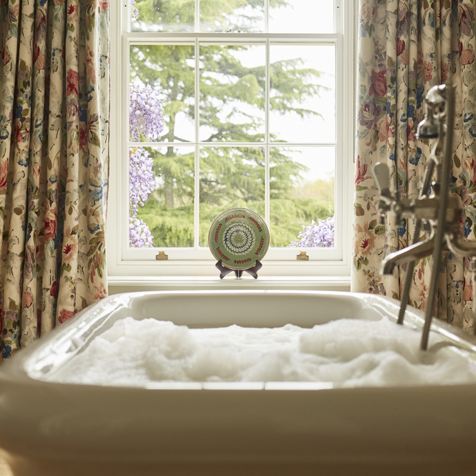A bath full of bubbles in front of a window
