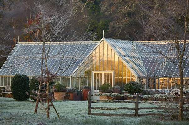A greenhouse with a fence and plants
AI-generated content may be incorrect.