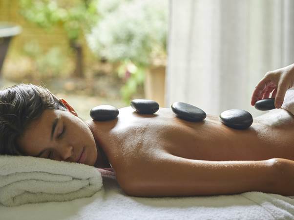 A person getting a hot stone massage
AI-generated content may be incorrect.